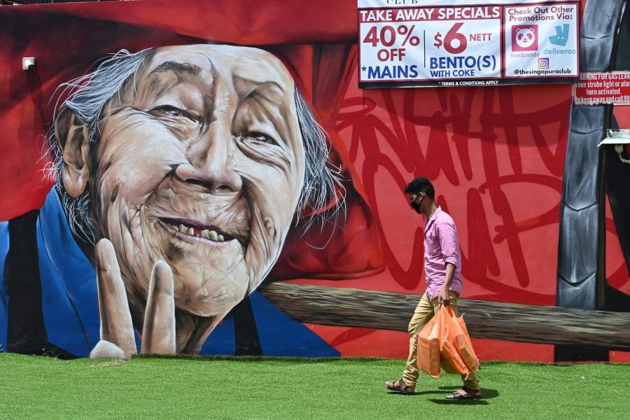A man walks past a wall mural of an elderly person in Singapore, 8 May 2020. (Roslan Rahman/AFP)