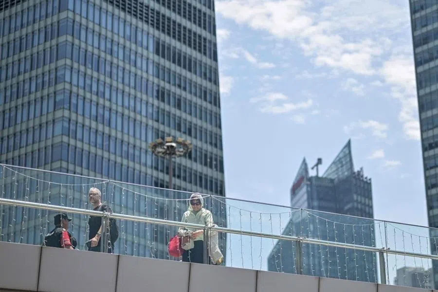 People walk on a bridge at the financial district of Lujiazui in Shanghai on 1 June 2026.