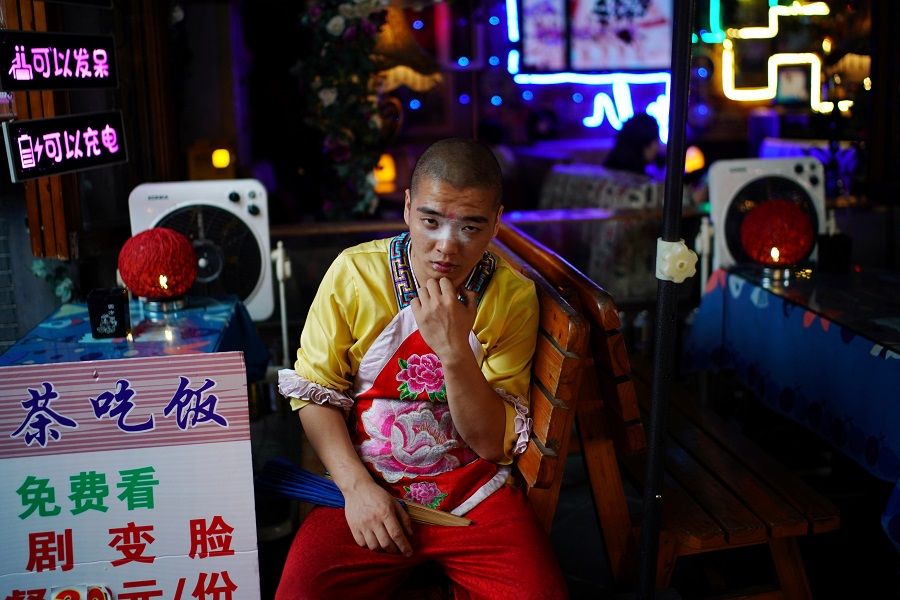 An opera performer waits for customers at a restaurant on Jinli Ancient Street, in Chengdu, Sichuan province, China, 8 September 2020. (Tingshu Wang/Reuters)