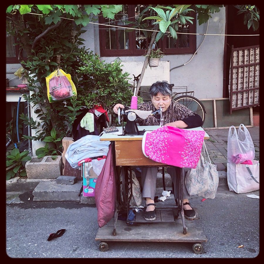 A typical presence in old neighborhoods, this seamstress in Yangpu, Shanghai is hard at work fixing many people's fabric-related problems.