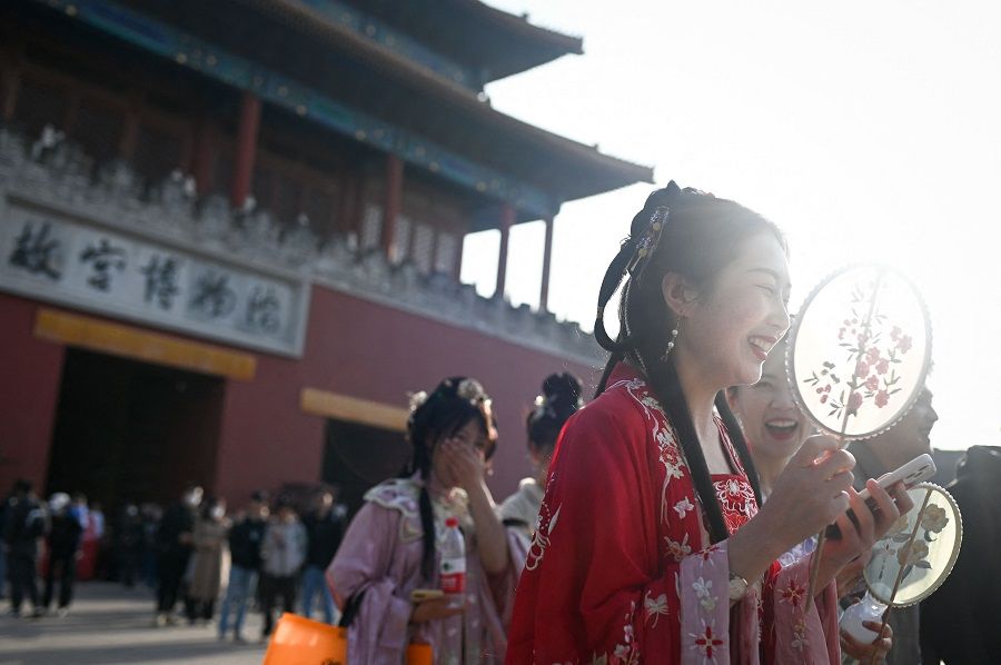 A group of women wearing traditional clothing walk out from the Forbidden City in Beijing, China, on 9 March 2023. (Wang Zhao/AFP)