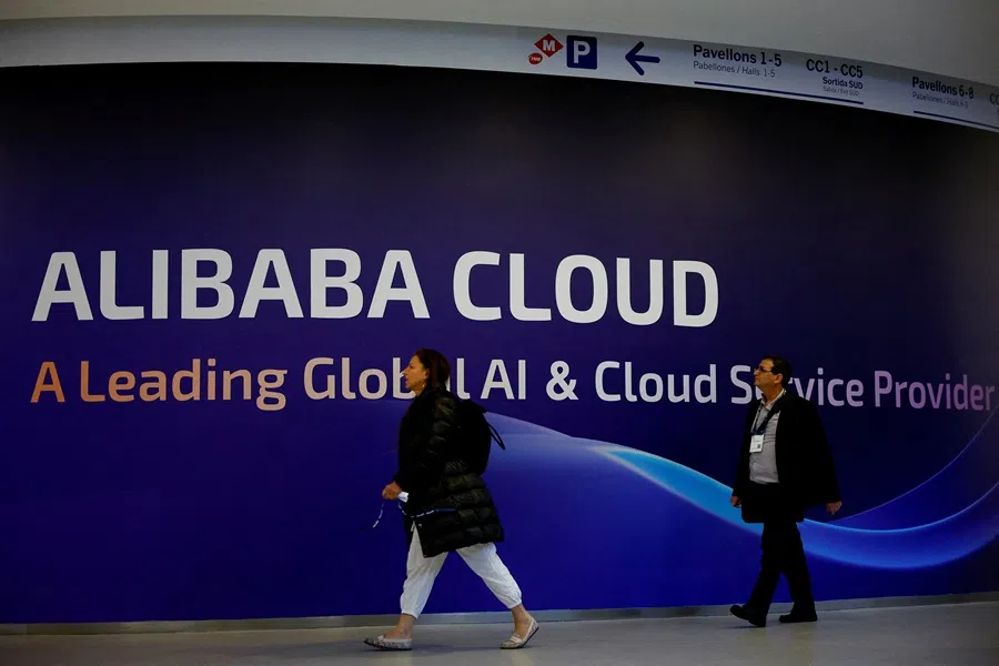 People walk past an Alibaba Cloud sign during the 2025 Mobile World Congress (MWC) in Barcelona, Spain, 3 March 2025. (Albert Gea/Reuters)