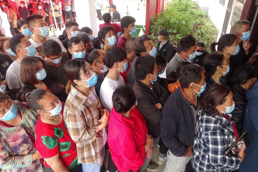 People queue to receive the Covid-19 coronavirus vaccine in Linquan county, Fuyang city, in China's eastern Anhui province on 13 May 2021. (STR/AFP)