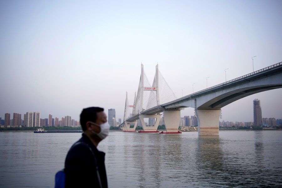 A man under a bridge of the Yangtze river in Wuhan, 15 April 2020. (Aly Song/REUTERS)