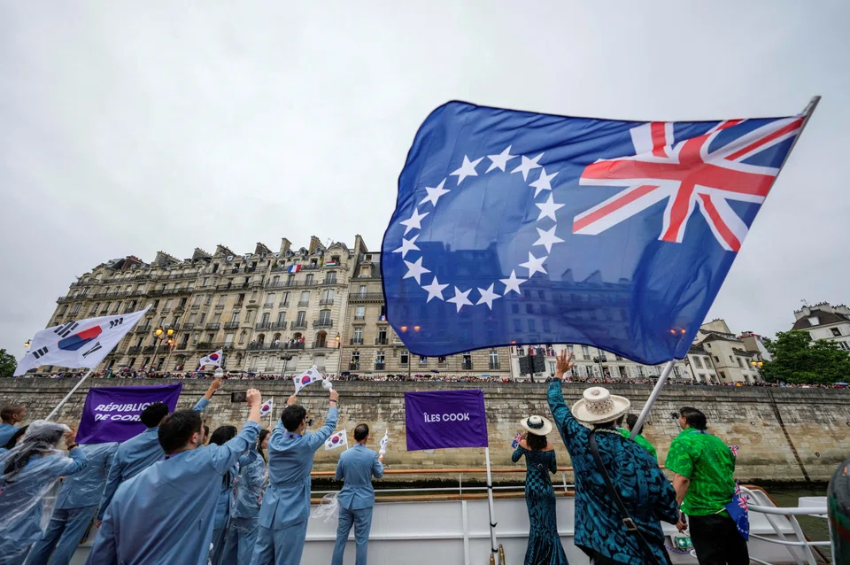 The Cook Islands flag being waved by the nation’s Olympic team from a boat during the opening ceremony of the 2024 Summer Olympics in Paris. (Lee Jin-man/Pool via Reuters)