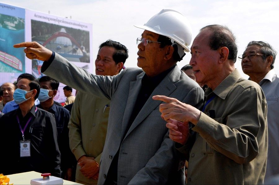 Cambodia's Prime Minister Hun Sen (centre) and tycoon Pung Kheav Se (second from right), chairman and board of director of Overseas Cambodian Investment Corporation (OCIC), gesture as Phnom Penh Governor Khuong Sreng (centre left) looks on during a ground breaking ceremony for the construction of a bridge across the Bassac river in Phnom Penh on 26 October 2020. (Tang Chhin Sothy/AFP)