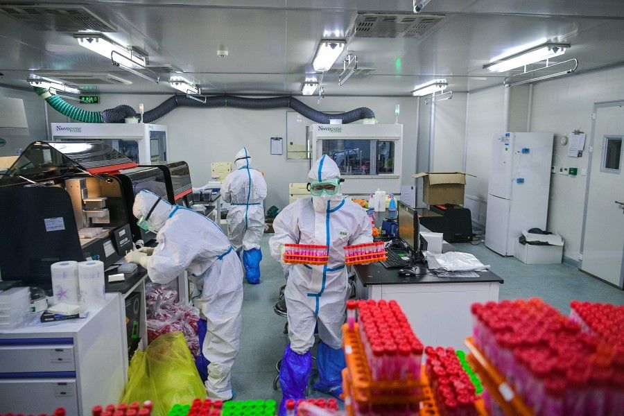 This photo taken on 23 November 2020 shows technicians processing Covid-19 coronavirus tests at a laboratory in Tianjin, China. (STR/CNS/AFP)