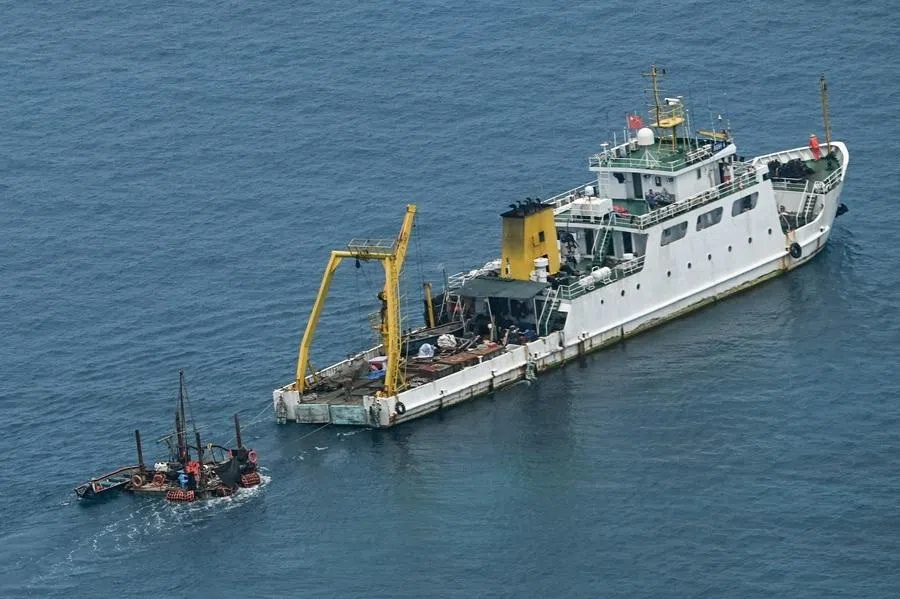 A ship identified by the Philippine Coast Guard as a Chinese research vessel is seen towing a floating structure at Scarborough Shoal in the disputed South China Sea on 15 June 2026.