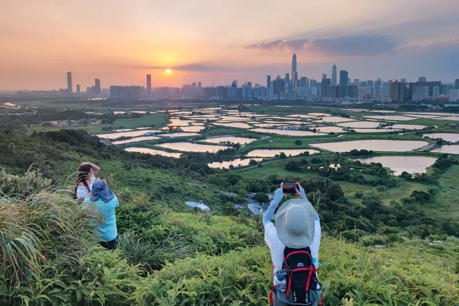 People at Ma Tso Lung village take photos of the sunset against the New Territories in northern Hong Kong, 20 October 2021. (CNS)