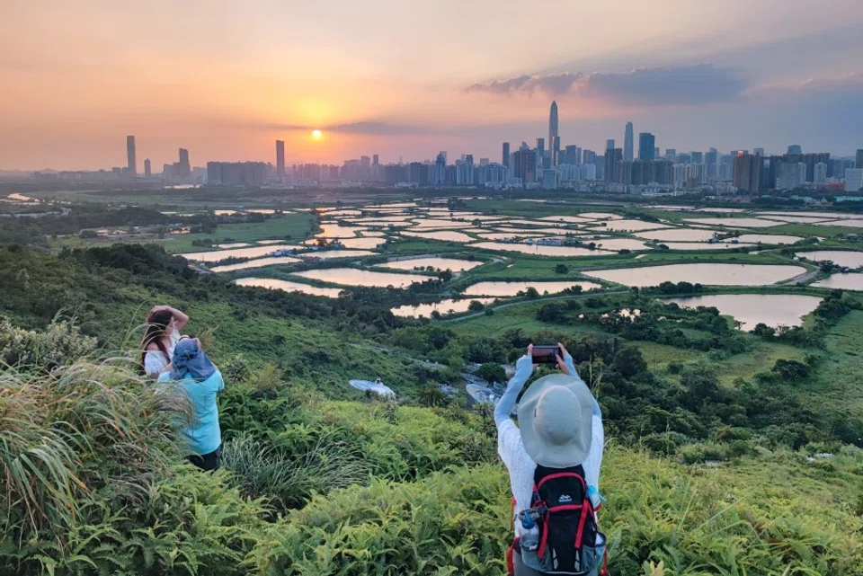 People at Ma Tso Lung village take photos of the sunset against the New Territories in northern Hong Kong, 20 October 2021. (CNS)