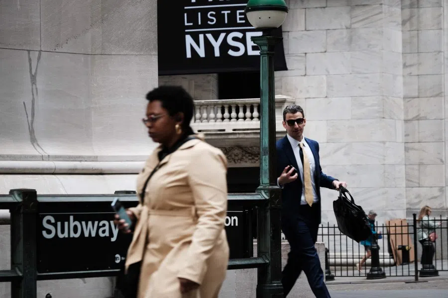 People walk along Wall Street outside of the New York Stock Exchange (NYSE) on 3 May 2023 in New York City. (Spencer Platt/Getty Images/AFP)