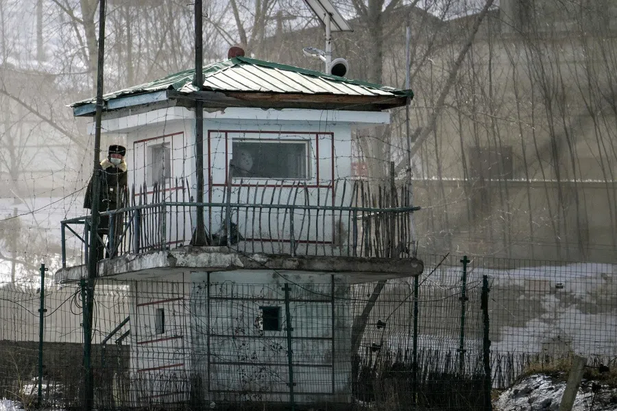 This picture taken on 1 March 2024 shows a watchtower on the border in the North Korean village of Hyesan as seen from Changbai in China’s northeast Jilin province. North Korean soldiers gaze across an icy river towards China, occasionally descending from looming watchtowers to prowl border paths behind barbed wire and sharpened sticks. (Pedro Pardo/AFP)