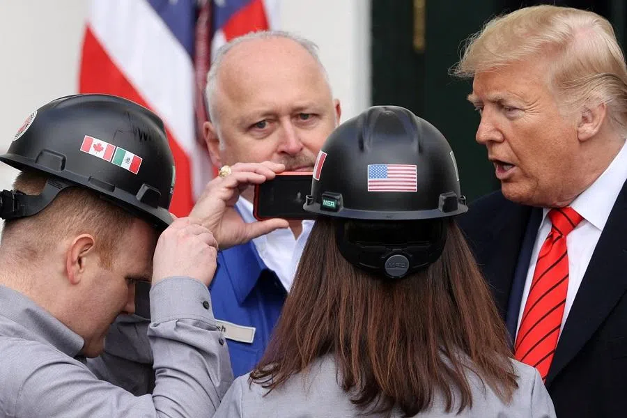 Attendees wearing hard hats with US, Mexican and Canadian flags greet US President Donald Trump after he signed the United States-Mexico-Canada Agreement (USMCA) trade deal at the White House in Washington, US, on 29 January 2020. (Jonathan Ernst/Reuters)