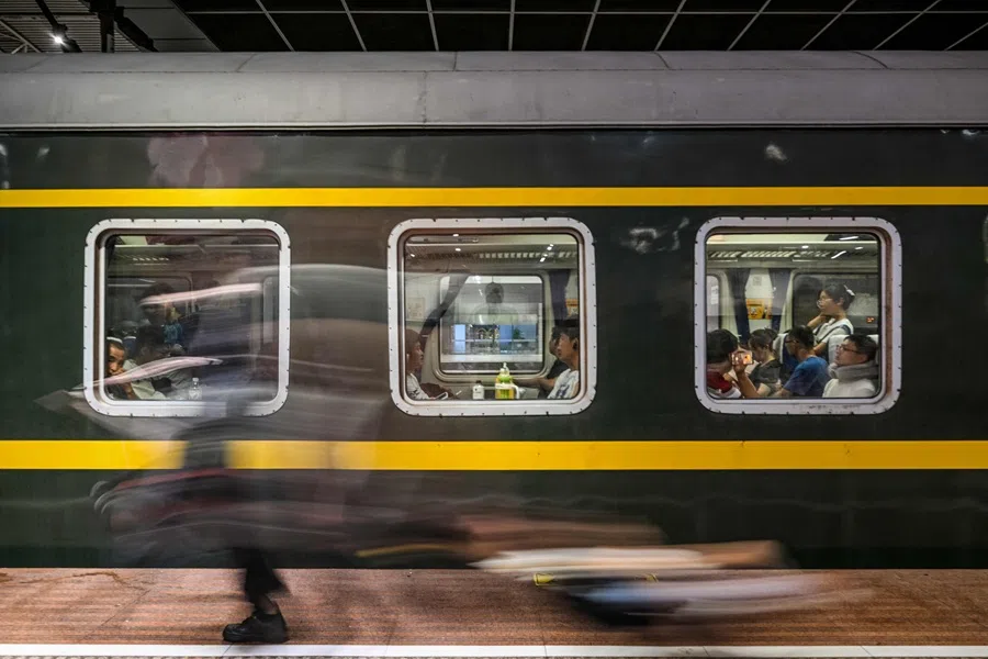 Passengers ride a train at the Shanghai Railway Station in Jing'an district of Shanghai on 20 July 2025.