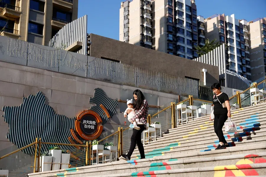 People walk at an Evergrande Plaza shopping mall in a residential compound developed by China Evergrande Group in Beijing, China, 22 September 2021. (Carlos Garcia Rawlins/Reuters)