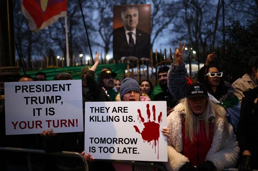 Anti-Iranian regime protesters wave Iranian flags during a gathering outside the Iranian Embassy, central London, on 12 January 2026. (Henry Nicholls/AFP)