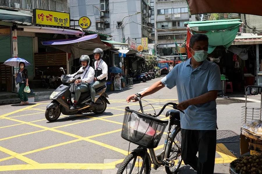 Men ride a scooter on a street in Taipei, Taiwan, 17 July 2024. (Ann Wang/Reuters)
