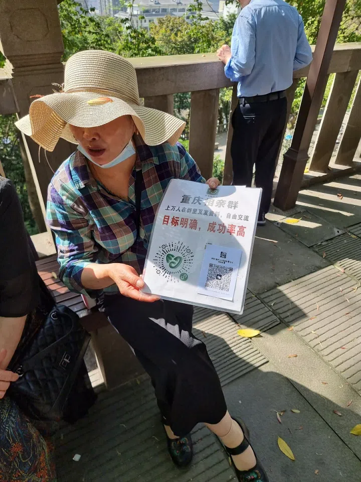 A matchmaker at the Chongqing matchmaking corner invites parents to scan the QR code to join the WeChat group, expanding their contacts to social platforms. (SPH/Edwin Ong)