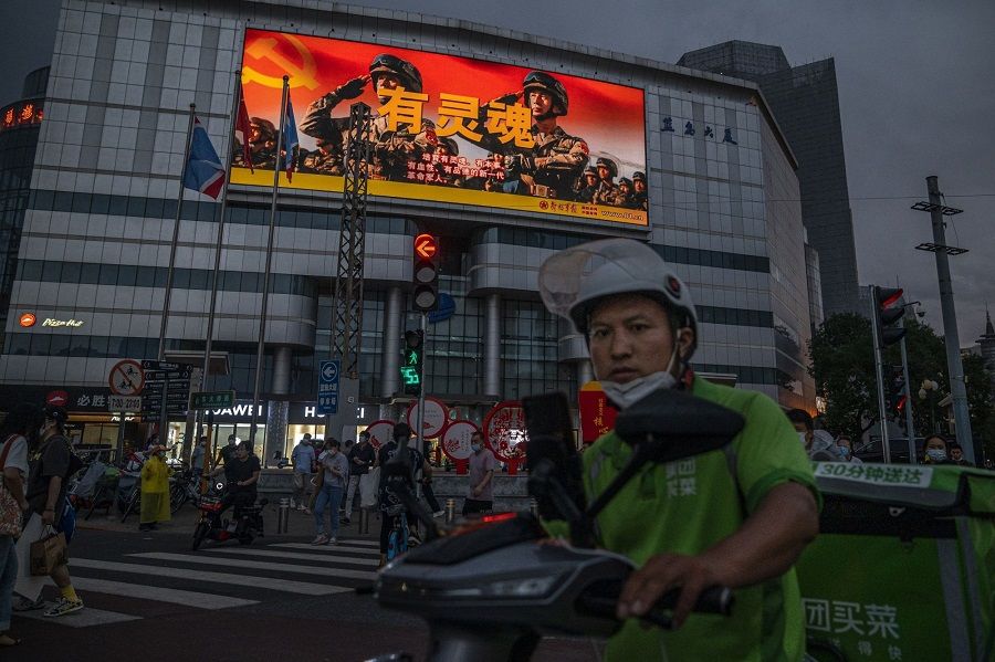 A screen displays a People's Liberation Army (PLA) advertisement at a crossroad in Beijing, China, on 30 August 2022. (Bloomberg)