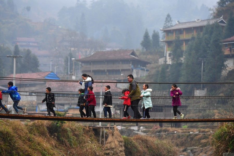 People on a bridge in a village in a Miao minority autonomous region in Liuzhou city, Guangxi, 30 January 2021. (Xinhua)