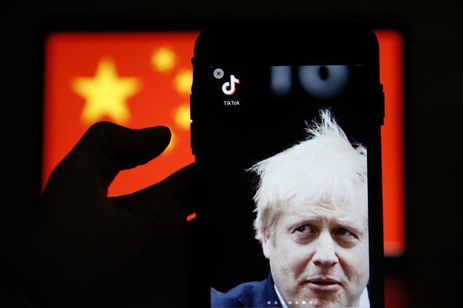 A photo of UK Prime Minister Boris Johnson and the TikTok app sit displayed in front of a national flag of China in this arranged photograph in London, 3 August 2020. (Hollie Adams/Bloomberg)