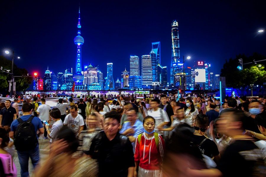People walk near the Bund, in front of Lujiazui financial district in Pudong, Shanghai, China, 10 May 2021. (Aly Song/Reuters)
