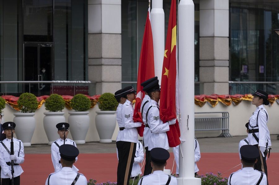 A Hong Kong Police Force Guard of Honor raises the flags of China. (Roy Liu/Bloomberg)