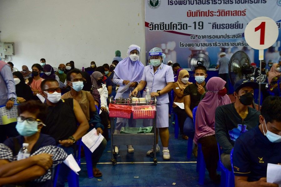 People wait before receiving doses of Sinovac's Covid-19 coronavirus vaccine at the Narathiwat Hospital compound in the southern province of Narathiwat on 5 August 2021. (Madaree Tohlala/AFP)
