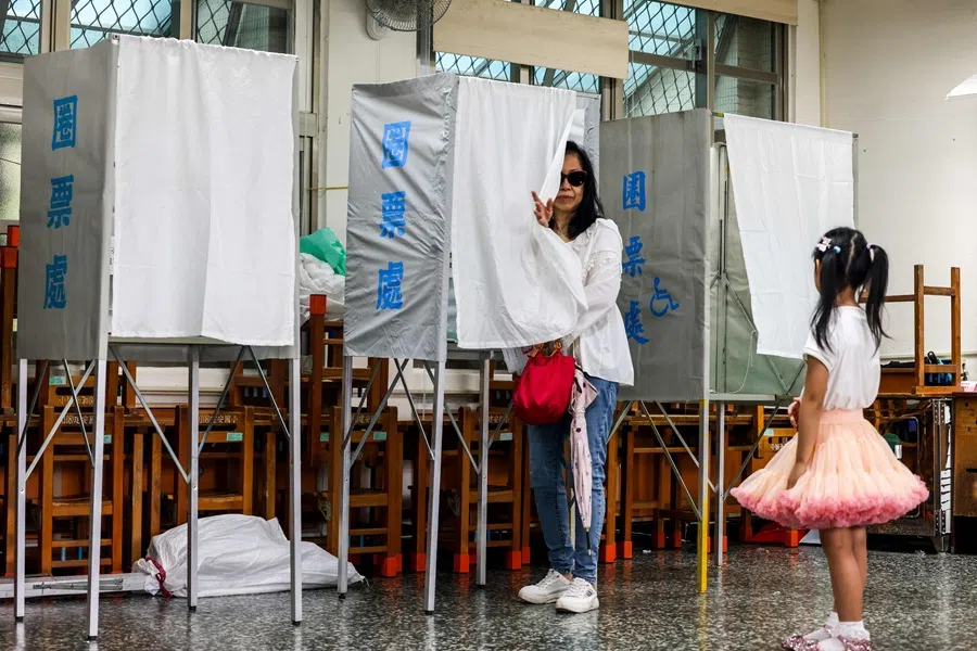 A child looks on as she waits for a family member to vote at a polling station during the recall election in Taipei on 26 July 2025. (I-Hwa Cheng/AFP)