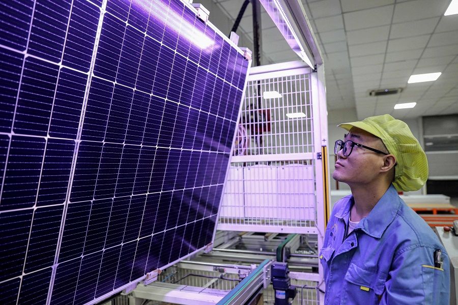 This photo taken on 5 September 2023 shows a worker producing solar photovoltaic modules used for solar panels at a workshop in Huaian city, in eastern China's Jiangsu province. (AFP)