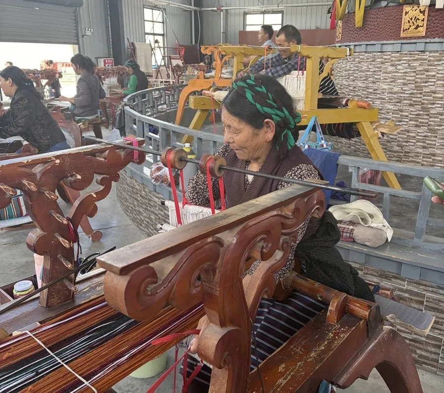 A Tibetan farmer is seen at one of the stations in a handicraft workshop, producing the traditional handicraft known as Tsethang serge, a traditional Tibetan woollen textile, on 29 July 2026.