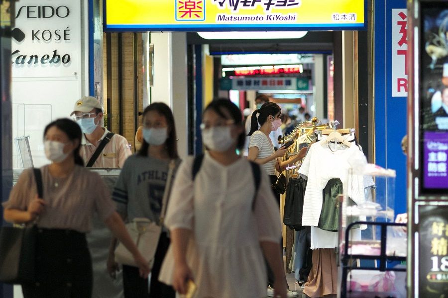 People walk past clothes vendors along Zhongxiao East Road, in Taipei, Taiwan, on 29 September 2022. (Sam Yeh/AFP)