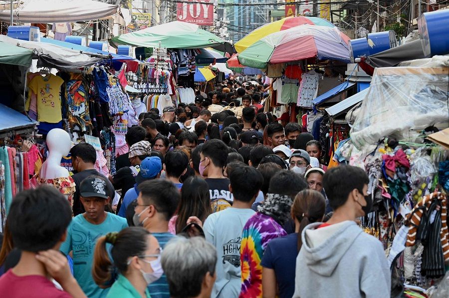 People shop along Divisoria in Manila, Philippines, on 21 December 2022. (Jam Sta Rosa/AFP)