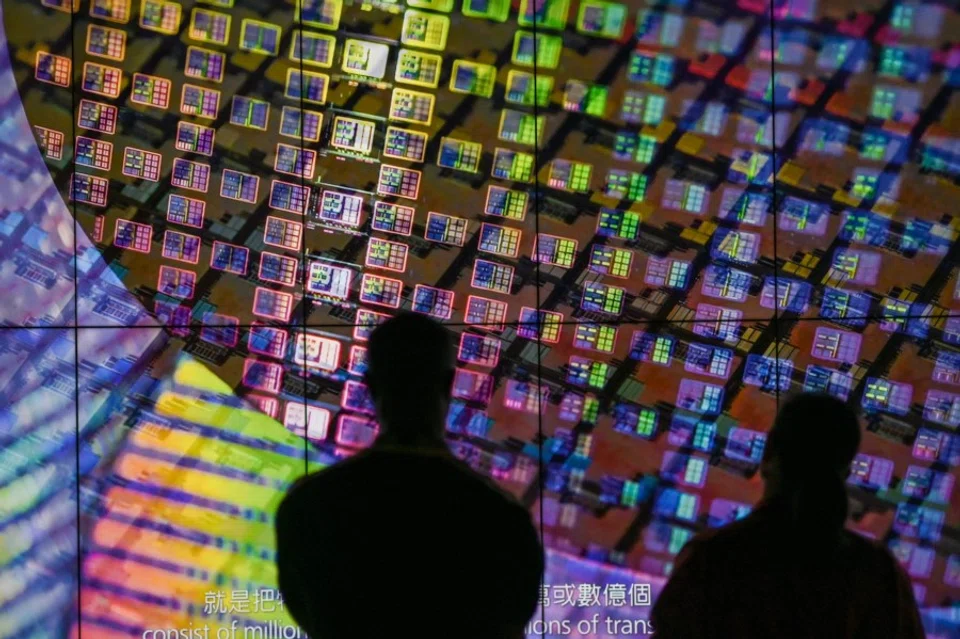 Visitors watch a wafer shown on screens at the Taiwan Semiconductor Manufacturing Company (TSMC) Renovation Museum at the Hsinchu Science Park in Hsinchu on 5 July 2023. (Sam Yeh/AFP)
