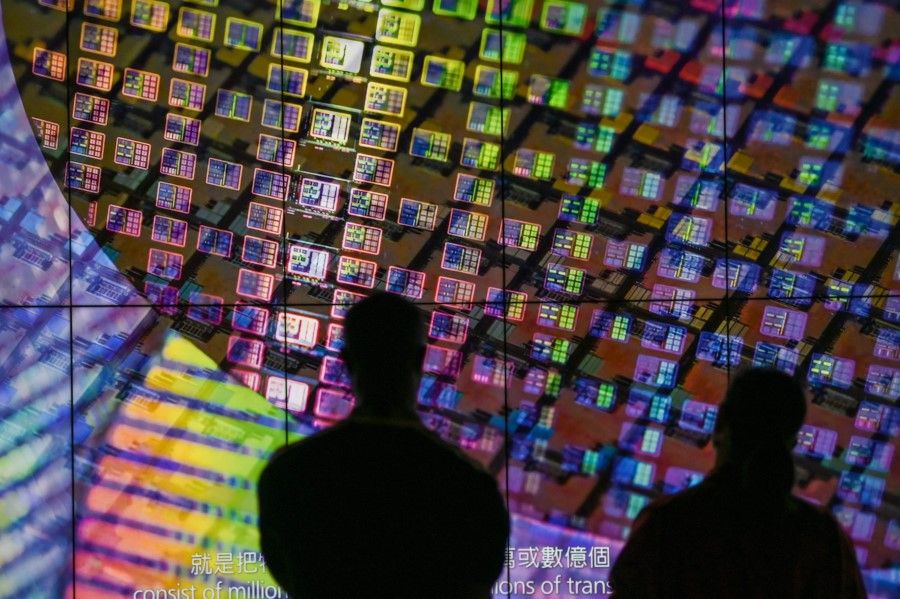Visitors watch a wafer shown on screens at the Taiwan Semiconductor Manufacturing Company (TSMC) Renovation Museum at the Hsinchu Science Park in Hsinchu on 5 July 2023. (Sam Yeh/AFP)