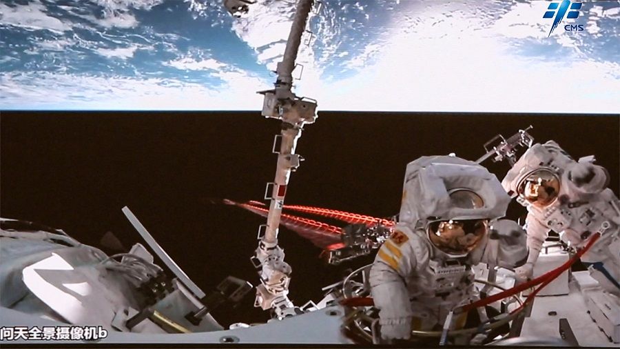 This handout image taken and released on 2 September 2022 by the China Manned Space Agency (CMSA) shows China's astronauts Chen Dong and Liu Yang returning to their cabin module after successfully completing a six-hour spacewalk. (Handout/China Manned Space Agency/AFP)