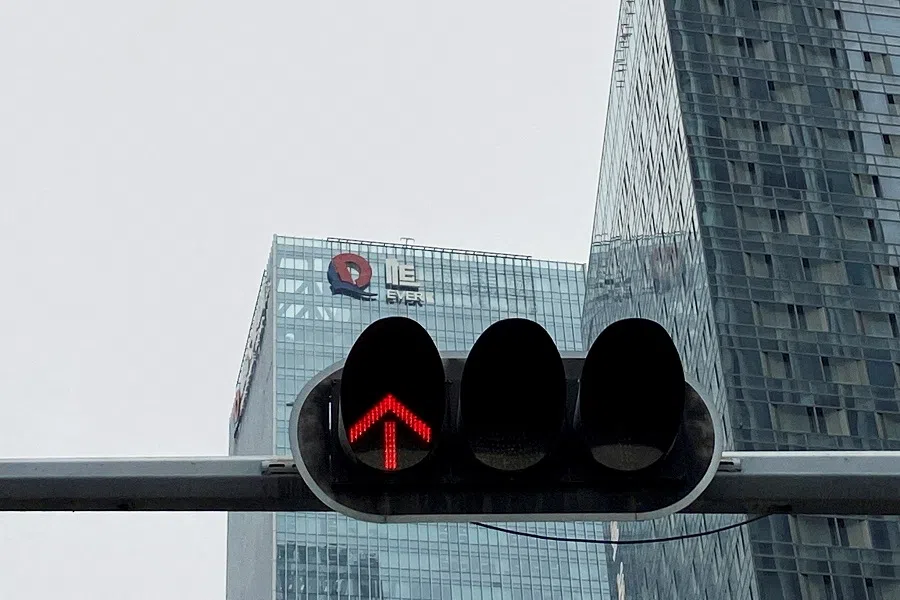 A partially removed company logo of China Evergrande Group is seen on the facade of its headquarters near a traffic light in Shenzhen, Guangdong province, China, on 10 January 2022. (David Kirton/Reuters)