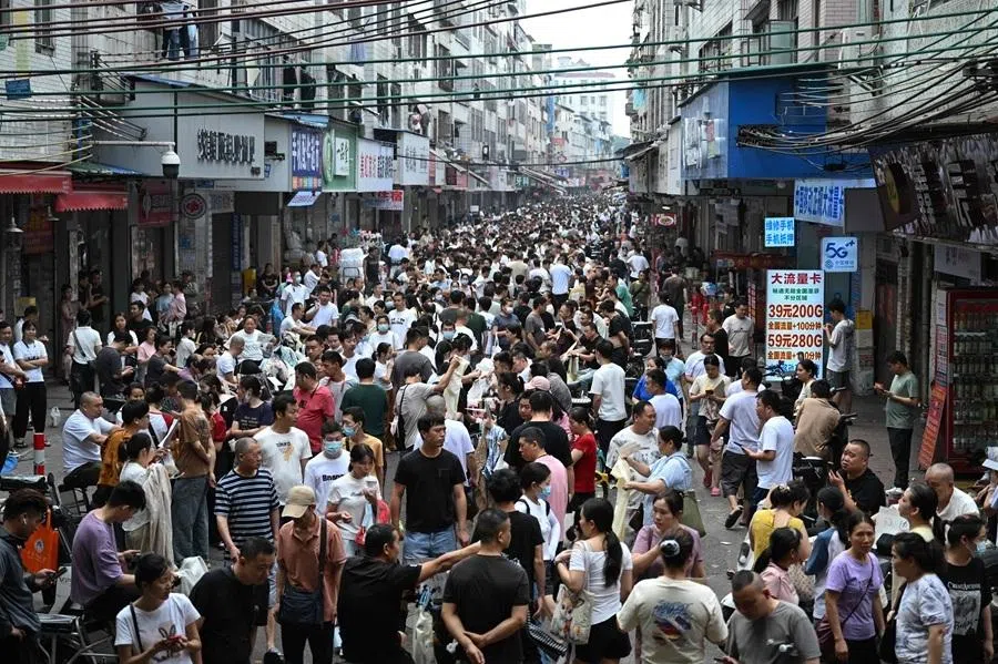 This picture taken on 27 April 2026 shows job-seeking labourers and recruiters from clothing factories on a street in an urban village in Guangzhou, in southern China's Guangdong province.