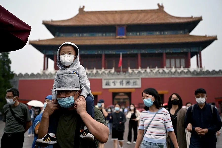A child looks on as people walk from an exit gate of the Forbidden City in Beijing, China, on 1 October 2022. (Noel Celis/AFP)