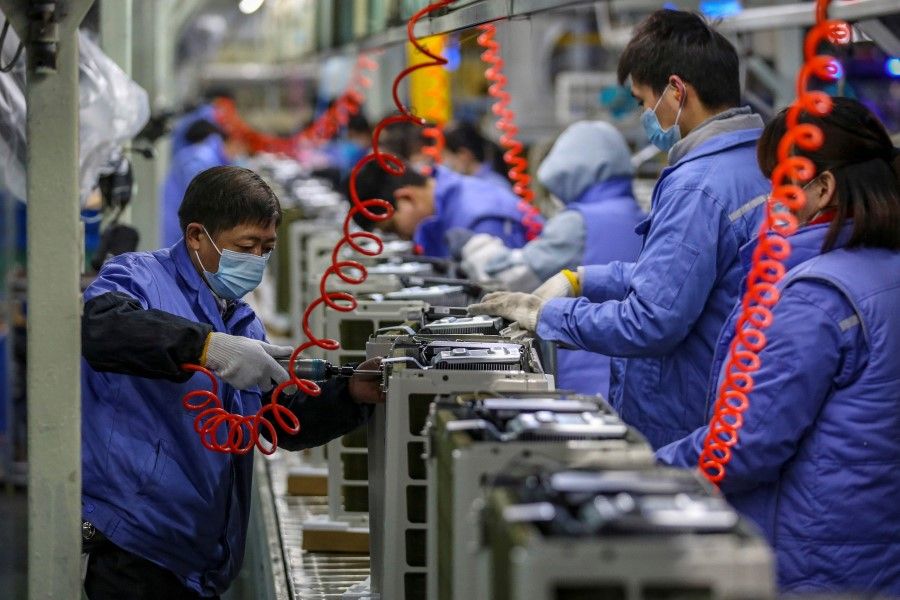 Employees work on an air conditioner production line at a Midea factory in Wuhan, in central China's Hubei province on 14 December 2020. (STR/AFP)