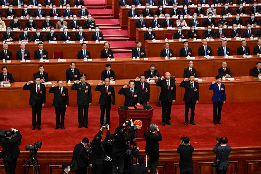 (From left to right) Newly-elected Chinese state councilor Qin Gang, state councilor and secretary-general of the State Council Wu Zhenglong, state councilor Li Shangfu, China's Vice Premiers Zhang Guoqing, Ding Xuexiang, He Lifeng, Liu Guozhong, Chinese state councilors Wang Xiaohong and Shen Yiqin swear an oath after they were elected during the fifth plenary session of the National People's Congress (NPC) at the Great Hall of the People in Beijing on 12 March 2023. (Noel Celis/AFP)