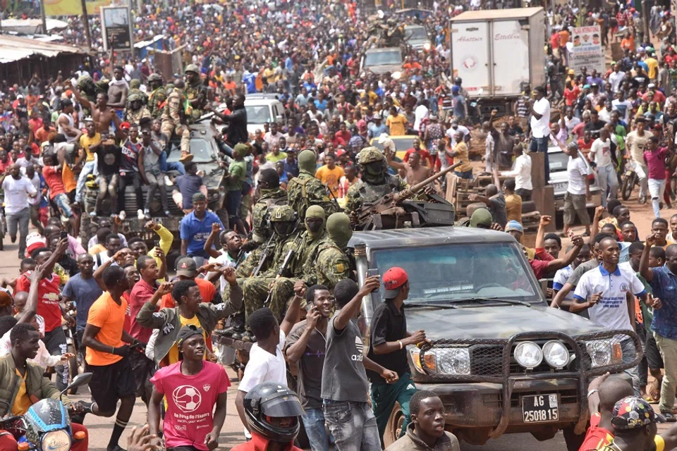 People celebrate in the streets with members of Guinea's armed forces after the arrest of Guinea's president, Alpha Conde, in a coup d'etat in Conakry, Guinea, 5 September 2021. (Cellou Binani/AFP)