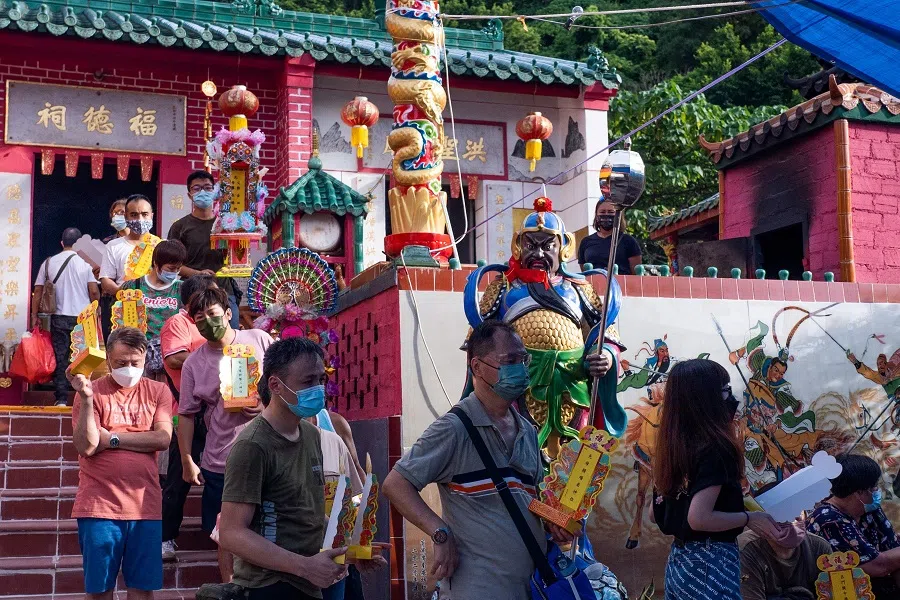 People hold their ancestral tablets at a temple in Hong Kong on 21 August 2021, marking the Hungry Ghost Festival. (Bertha Wang/AFP)