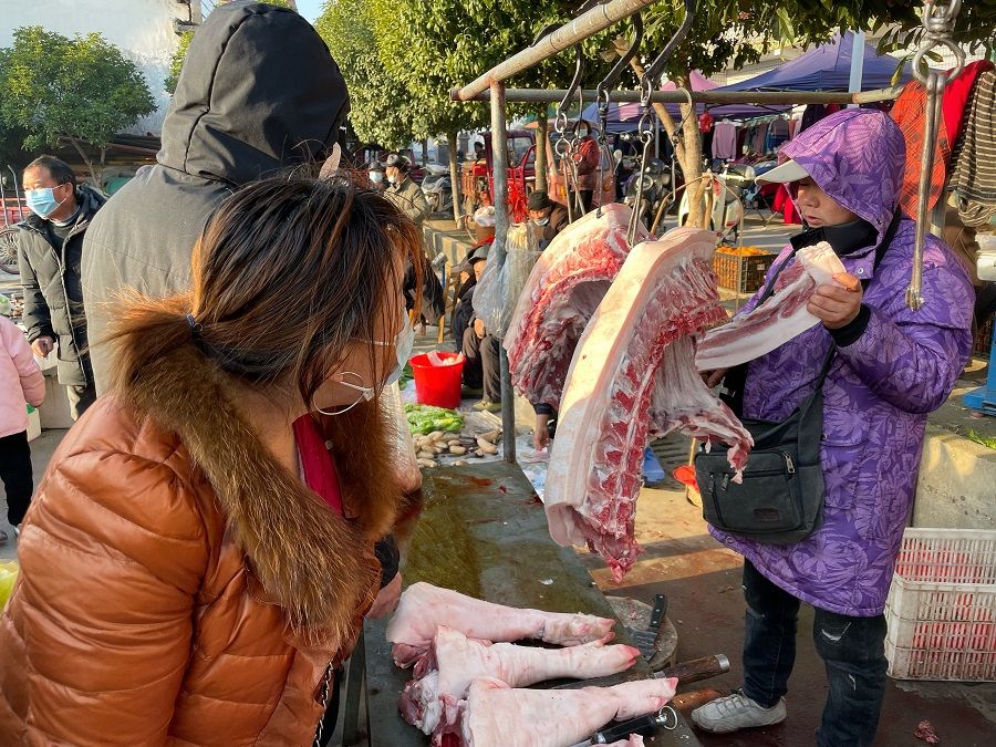 People shop at the market in Zhangjiajie, 8 January 2023.