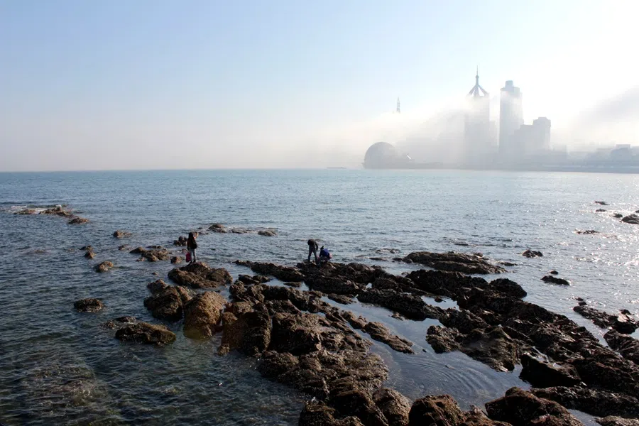 View from Zhanqiao Pier towards contemporary Qingdao’s skyscrapers, shrouded in mist.