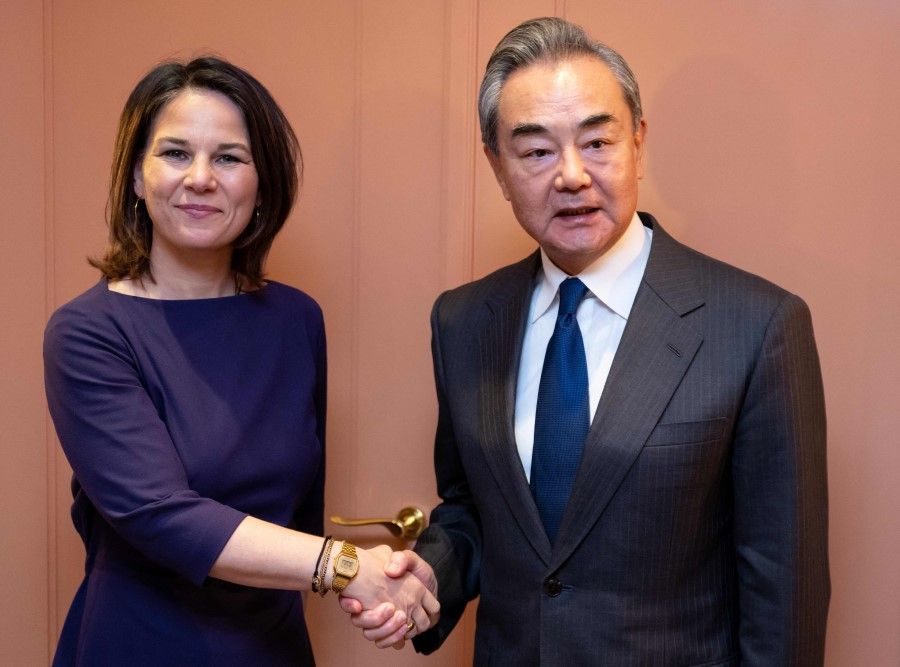 German Foreign Minister Annalena Baerbock (left) and China's Director of the Office of the Central Foreign Affairs Commission Wang Yi shake hands at their bilateral meeting during the Munich Security Conference (MSC) in Munich, southern Germany, on 17 February 2023. (Sven Hoppe/AFP)