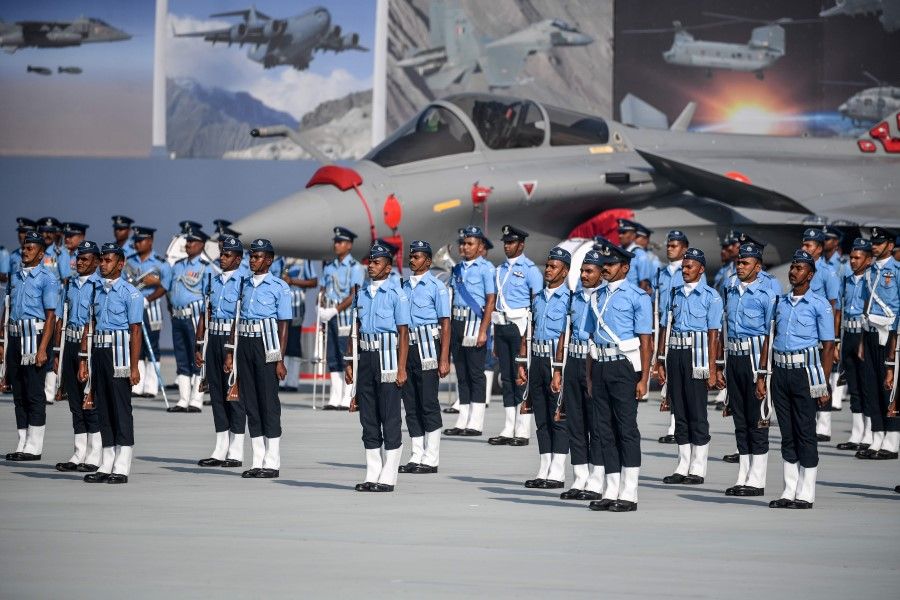 Indian Air Force (IAF) soldiers stand next to the newly launched Rafale fighter jet during the 88th Air Force Day parade at Hindon Air Force station in Ghaziabad on 8 October 2020. (Money Sharma/AFP)