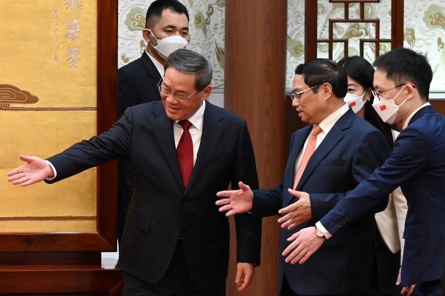 Chinese Premier Li Qiang leads the way for Vietnam's Prime Minister Pham Minh Chinh as they arrive for a signing ceremony in the Great Hall of the People in Beijing on 26 June 2023. (Greg Baker/Pool via Reuters)