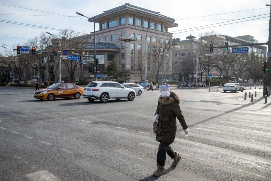 A pedestrian wearing a face shield in Beijing, China, on 14 December 2022. (Bloomberg)