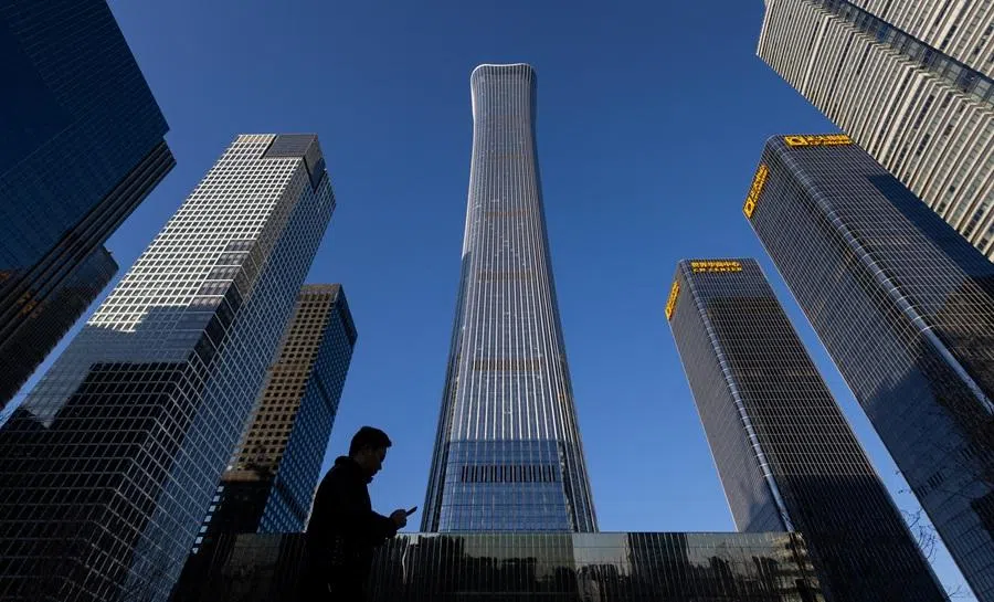 A man walks next to skyscrapers of the Central Business District in Beijing, China, on 5 January 2026. (Maxim Shemetov/Reuters)
